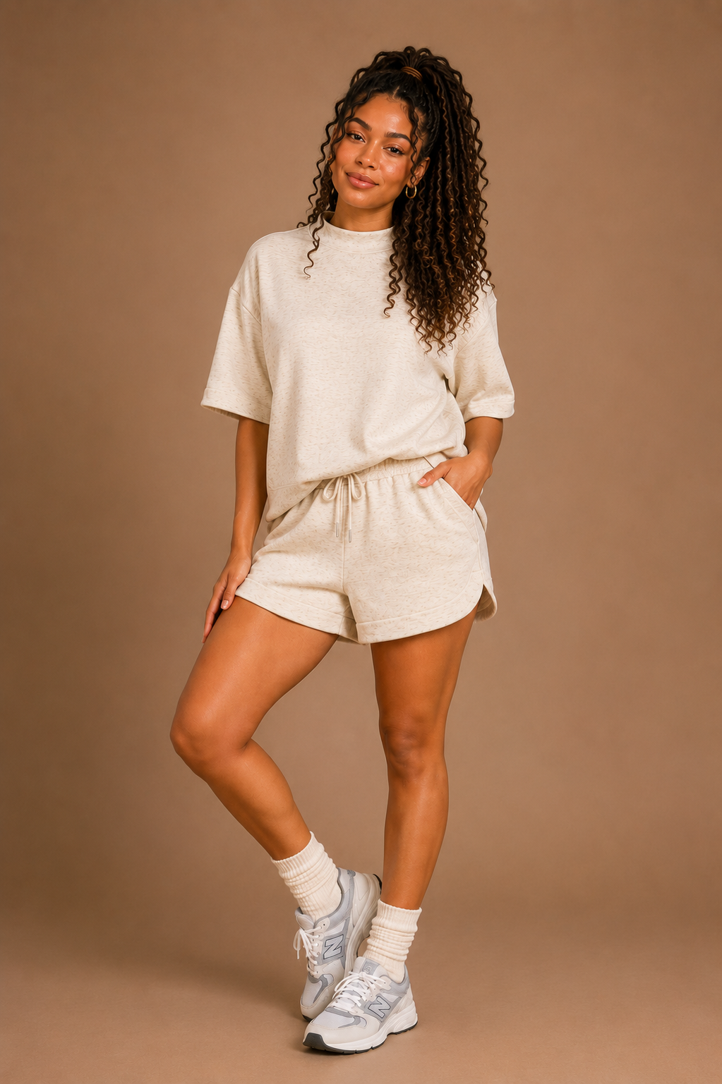 Woman wearing a beige outfit with shorts and a t-shirt on a brown background